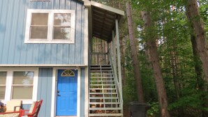 Un bâtiment à deux étages avec une porte bleue et un porche abrité.