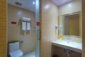 A bathroom with a toilet, a sink with a mirror, and a towel rack. - Fubang Hotel (Yichun)