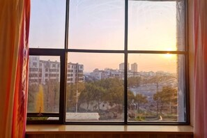 A window with a view of buildings and trees. - Fubang Hotel (Yichun)