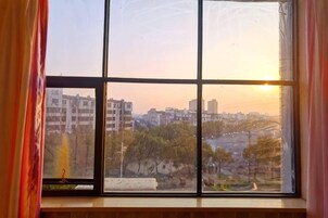Una ventana con vistas a un paisaje urbano al atardecer.