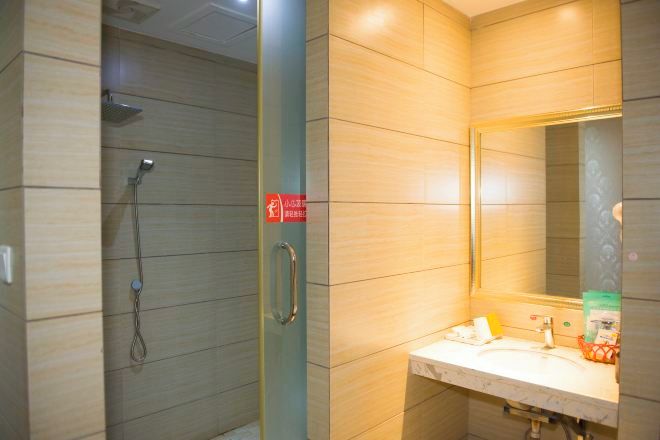 Un baño con ducha, lavamanos y espejo.