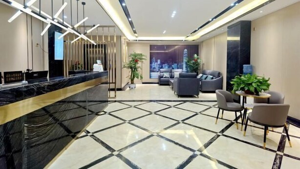 A modern hotel lobby with a reception desk, seating area, and a cityscape view. - Fubang Hotel (Yichun)