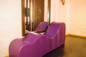 A massage chair in a room with patterned wallpaper and a large mirror. - Fubang Hotel (Yichun)