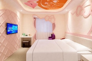 Un dormitorio moderno con una cama grande, televisión, escritorio y una silla.