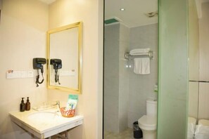 A bathroom with a sink, mirror, hairdryer, and a shower area with a towel rack. - Fubang Hotel (Yichun)