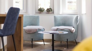 A room with two armchairs, a small round table, and a wooden chair. - Gasthaus zur Traube (Uffenheim)