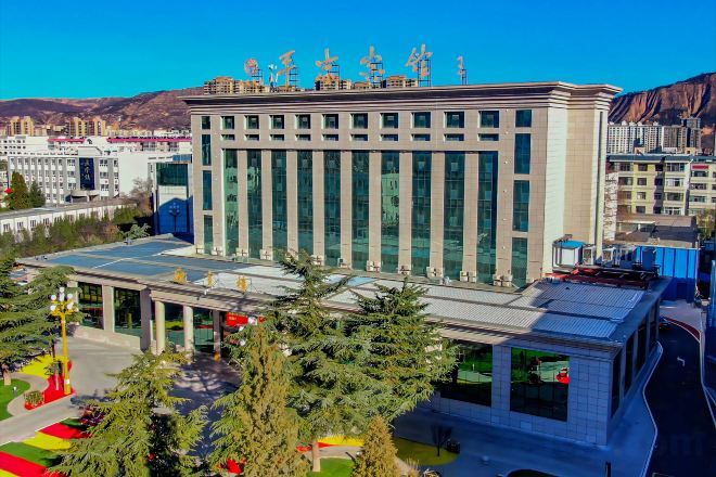 Un edificio moderno con techo plano, ventanas amplias y una entrada central.