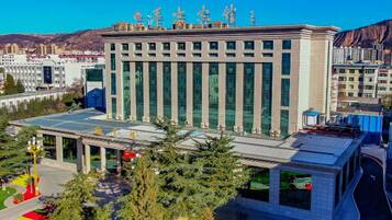 Un edificio moderno con techo plano, ventanas amplias y una entrada central.