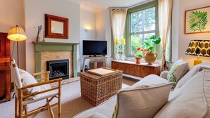 A cozy living room with a fireplace, a television, and comfortable seating. - Pass the Keys | Charming Victorian Terrace in centre of Cambridge (Cambridge)