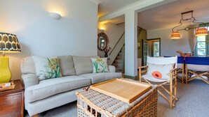 A living room with a sofa, a coffee table, and a wicker basket. - Pass the Keys | Charming Victorian Terrace in centre of Cambridge (Cambridge)