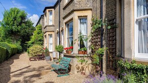 A traditional stone building with multiple windows and a gravel pathway. - Pass the Keys | Charming Victorian Terrace in centre of Cambridge (Cambridge)