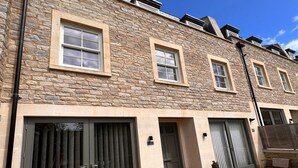 A row of townhouses with stone facades, large sliding doors, and a tiled courtyard. - Boutique private apartment convenient for city - Pass the Keys (Bath)