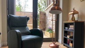 A modern living room with a leather recliner, a floor lamp, and a bookshelf. - Boutique private apartment convenient for city - Pass the Keys (Bath)