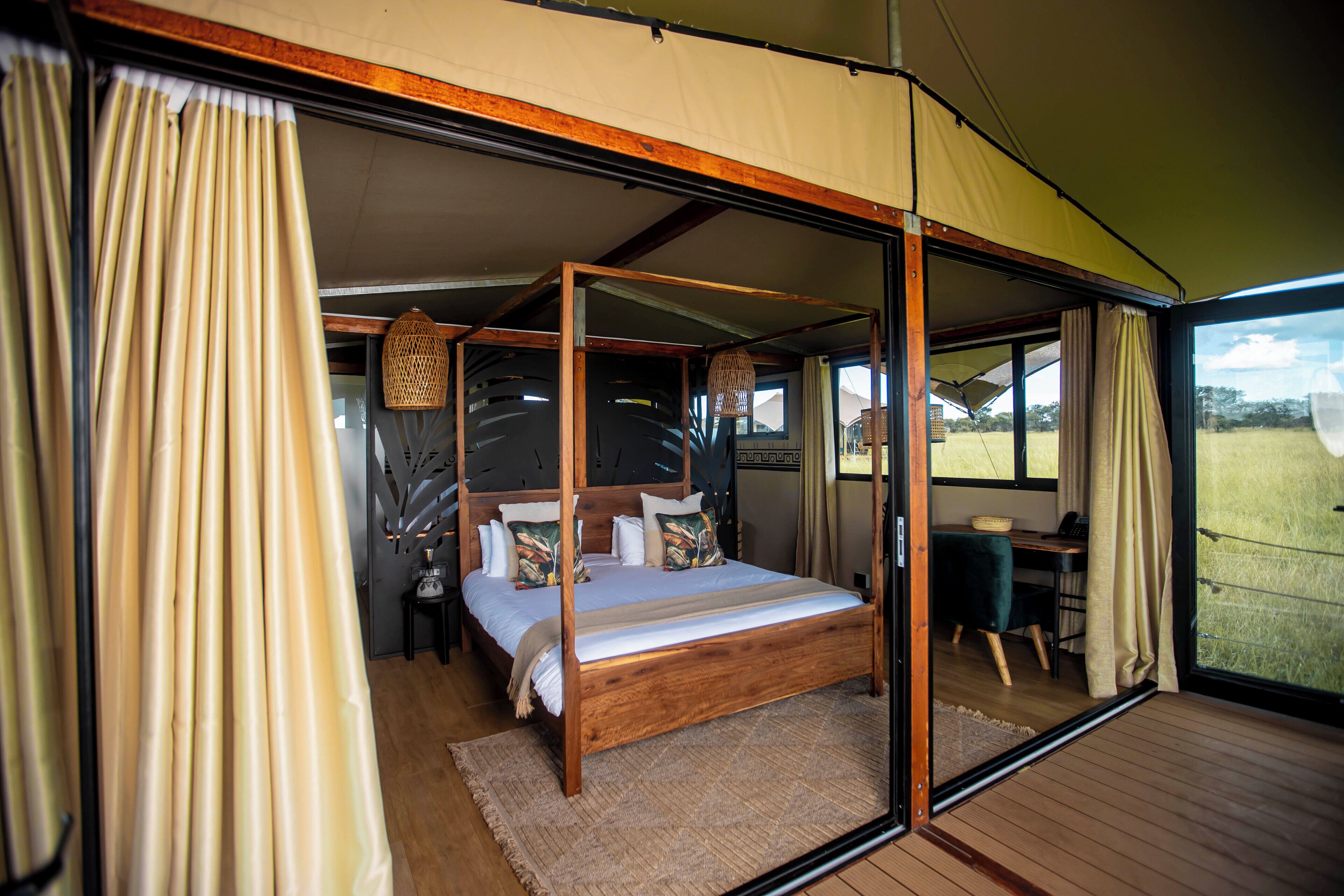 Un dormitorio espacioso con cama con dosel, un escritorio y vistas al exterior.