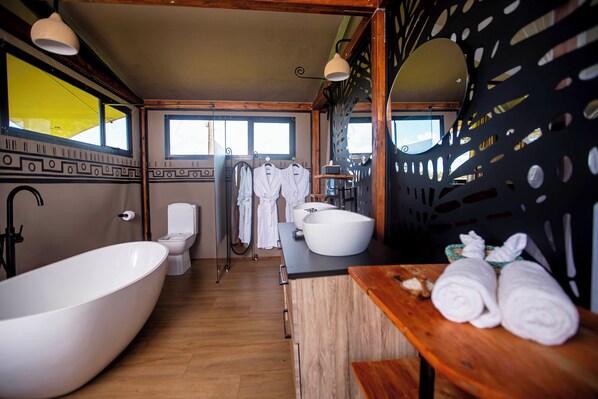 Une salle de bain moderne avec une baignoire sur pieds, des toilettes et un lavabo.