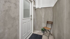 A narrow, enclosed outdoor space with a white door, a small bench, and a potted plant. - Home Base for Winter Ski Adventure & Salt Lake City Events (Sandy)