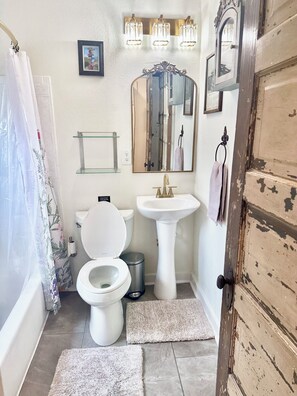 A bathroom with a toilet, sink, and shower curtain.