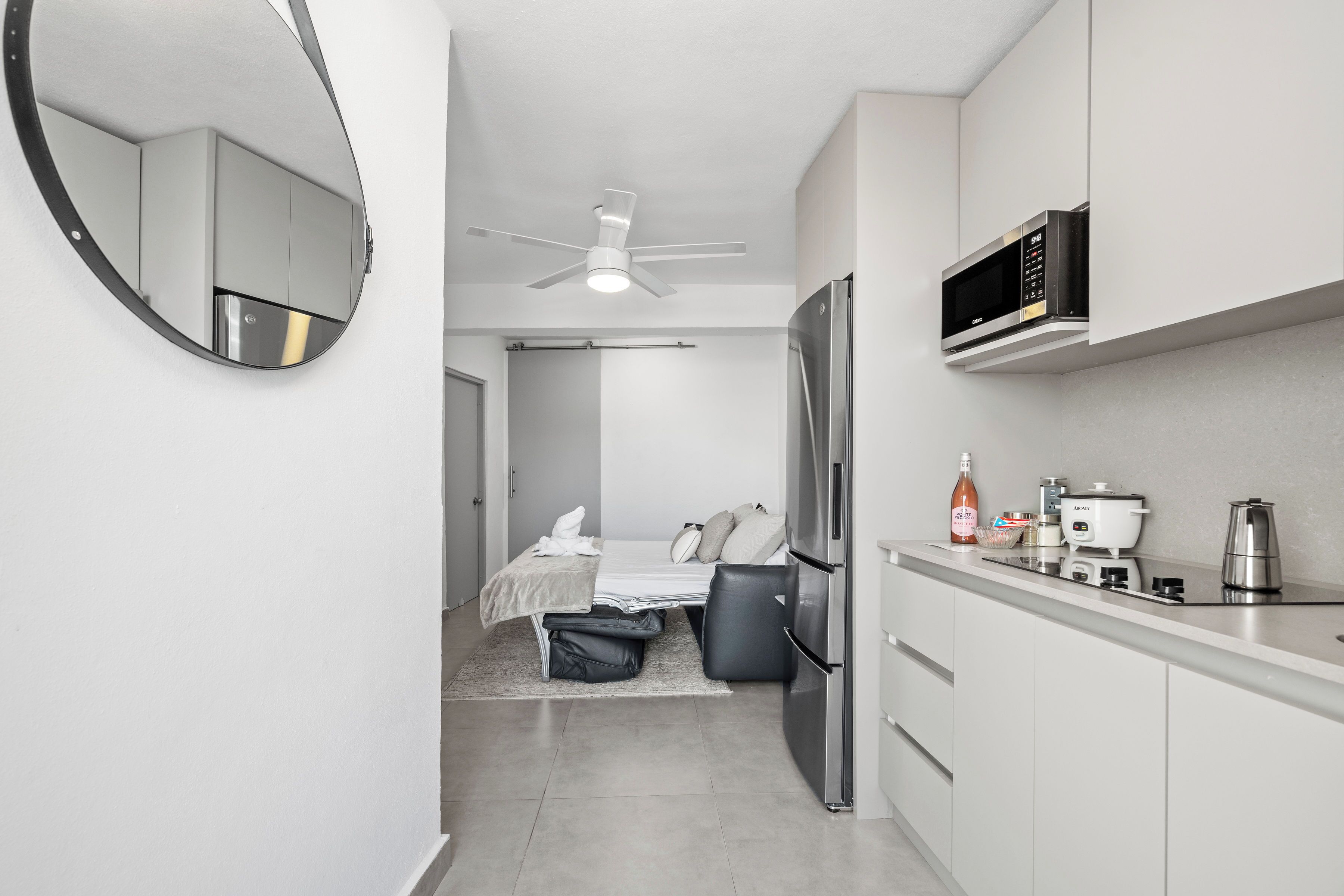 A compact kitchen with a microwave, refrigerator, and coffee maker.