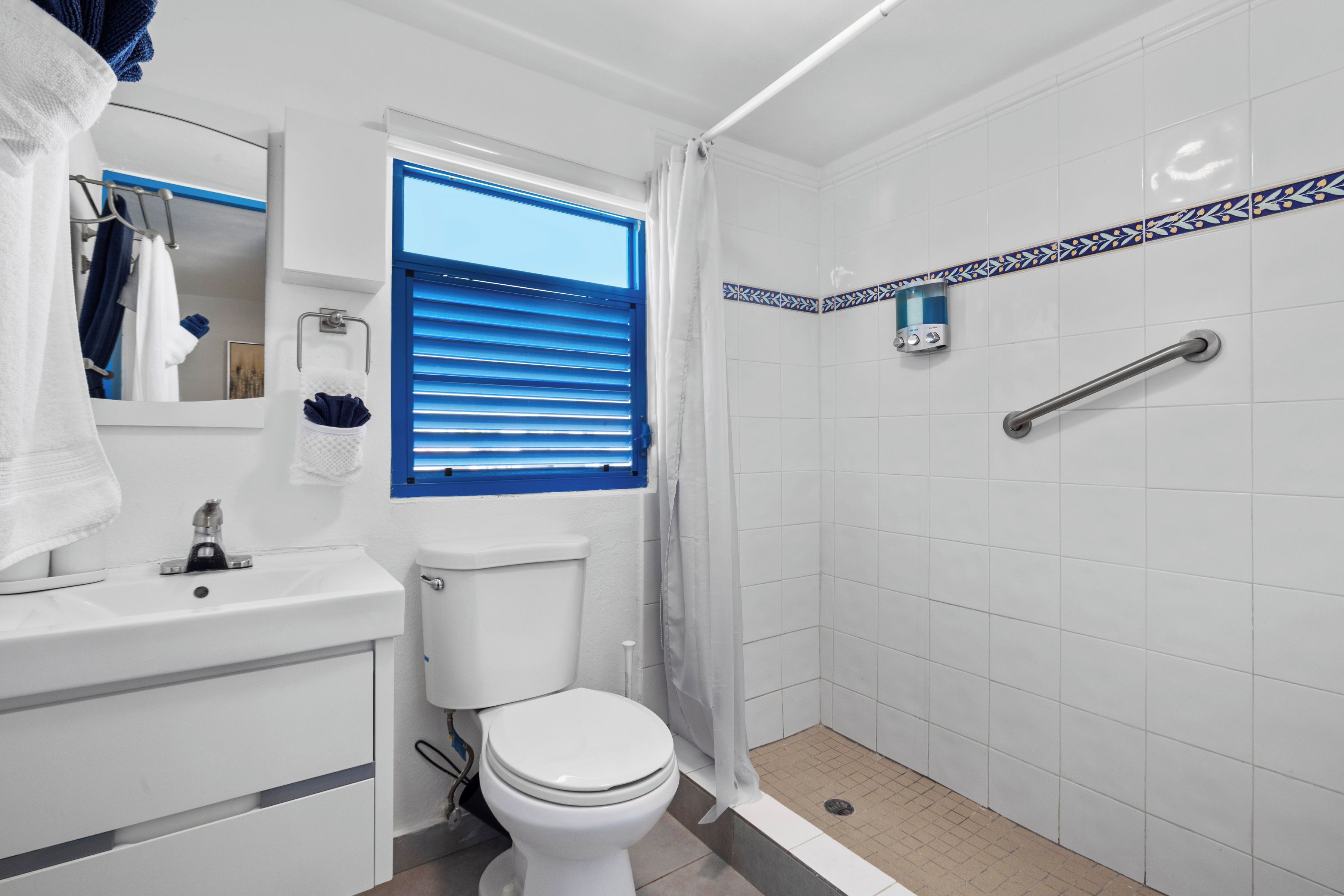 A bathroom with a toilet, sink, and shower.