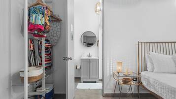 Une chambre à coucher avec un lit, une table de chevet et une vue sur la salle de bain.