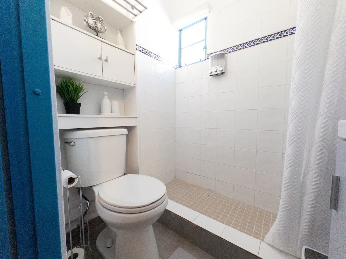 Un baño con inodoro, ducha y lavamanos.