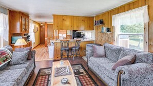 Een gezellig interieur van een vakantiehuisje met een woonkamer, keuken en eetgedeelte.