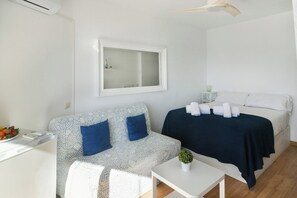 Une chambre d’hôtel avec un lit, un canapé, une petite table et un miroir au mur.