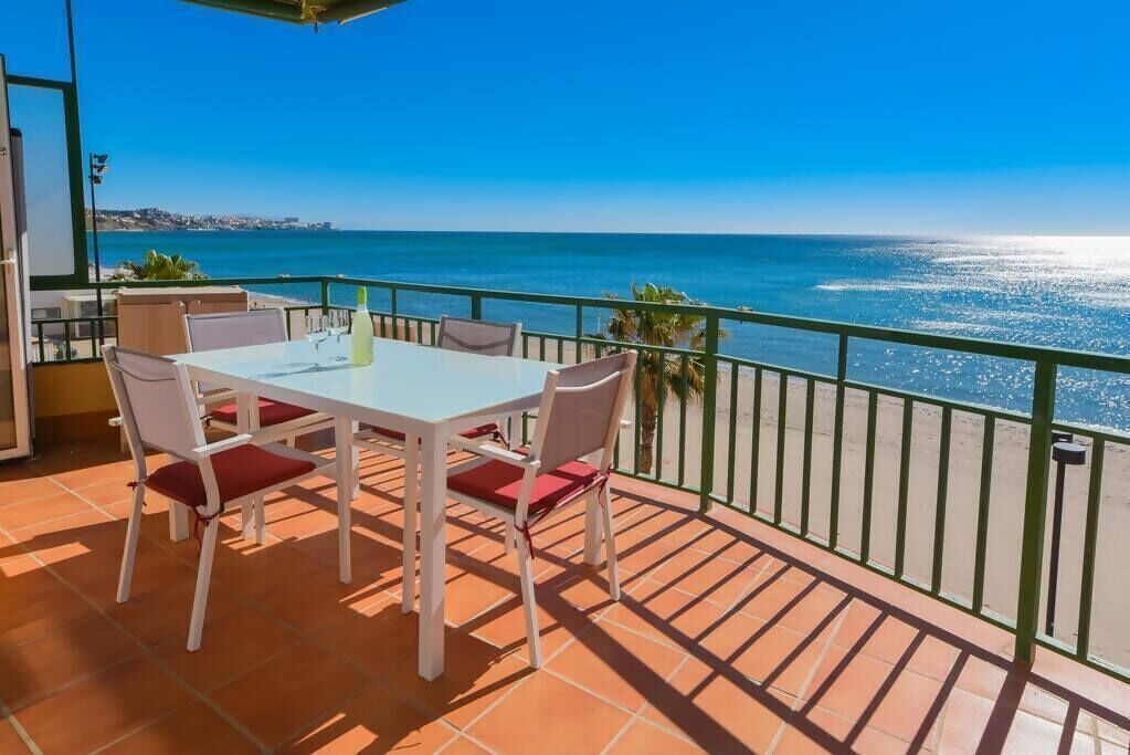 Une terrasse avec une table et des chaises, offrant une vue sur la côte.