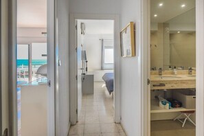 A modern hotel room with a view of the sea, a bathroom with a large mirror, and a bedside table with toiletries. - Over the sea - beachfront with amazing views (Fuengirola)