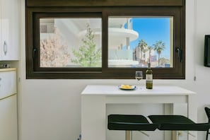A small kitchenette with a white countertop, a wine bottle, and a glass. - Lovely apartment 50m from the beach! (Fuengirola)