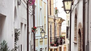 A narrow street with buildings on either side, featuring balconies with potted plants and hanging flower baskets. - CASA PINA BED & BREAKFAST (Spoltore)