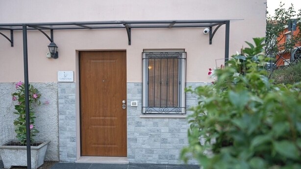 A building with a wooden door, a small window with metal bars, and a sign above the door. - CASA PINA BED & BREAKFAST (Spoltore)