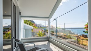 Ein Balkon mit Meerblick und einem Stuhl.