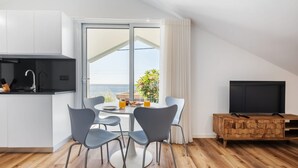 Eine moderne Küche mit Essbereich, einem Fernseher und einem Balkon mit Blick.
