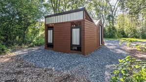 A small, wooden cabin with a sloped roof, surrounded by gravel and trees. - Seneca Hideaway/Romantic Getaway Cabin/Hot Tub (Geneva)