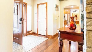 A spacious hallway with wooden floors and a stone accent wall.
