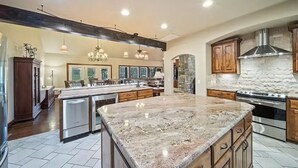 A spacious kitchen with a large island, granite countertops, and stainless steel appliances.