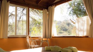 A room with a bed, a chair, and a window with curtains. - Apart Suites & Cabañas Duendes del Pungo (La Cumbre)