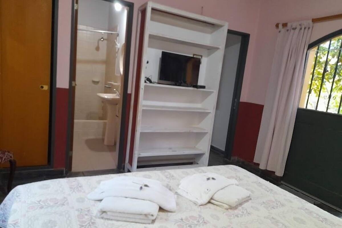 Une chambre à coucher avec un lit, une armoire et une salle de bain.