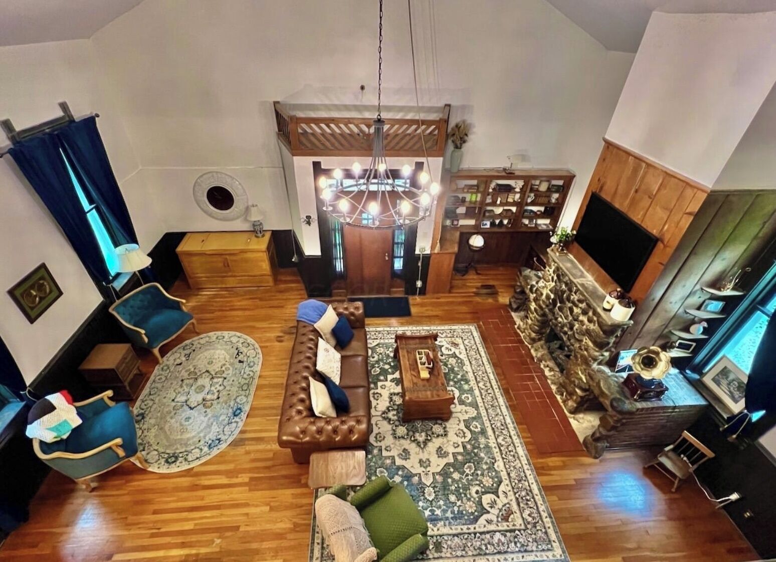 Ein geräumiges Wohnzimmer mit Kamin, großem Teppich und einer gemütlichen Sitzecke.