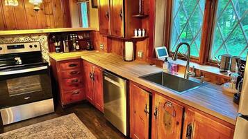 Una cucina con mobili in legno, elettrodomestici in acciaio inossidabile e una finestra vista verde.