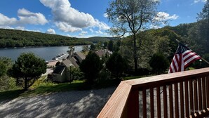 A lakeside view with a dock, a small house, and an American flag. - Lake Loft at Deep Creek Lake (Oakland)