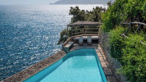 A swimming pool with a view of the sea and a mountain in the background. - Villa Luna by MyVillaCollection (Maiori)