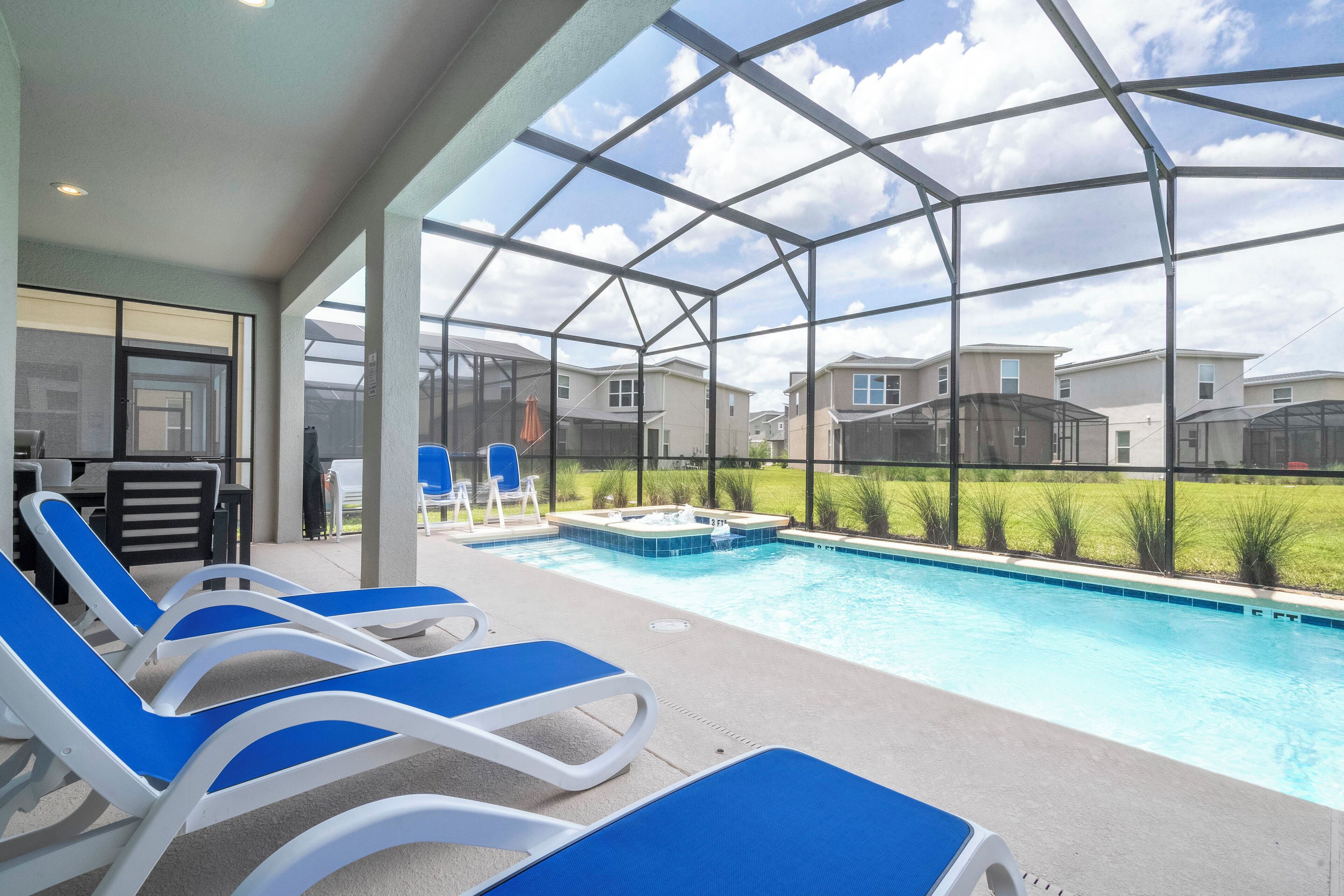 Piscina descoberta coberta com espreguiçadeiras, hidromassagem e vista para edifícios residenciais.