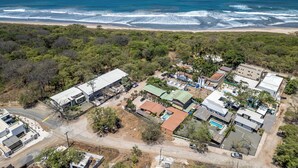 An aerial view of a coastal residential area with houses, a beach, and the ocean. - Cozy Seaside AC Cabin, 300m from ocean, with pool (Provincia de Guanacaste)