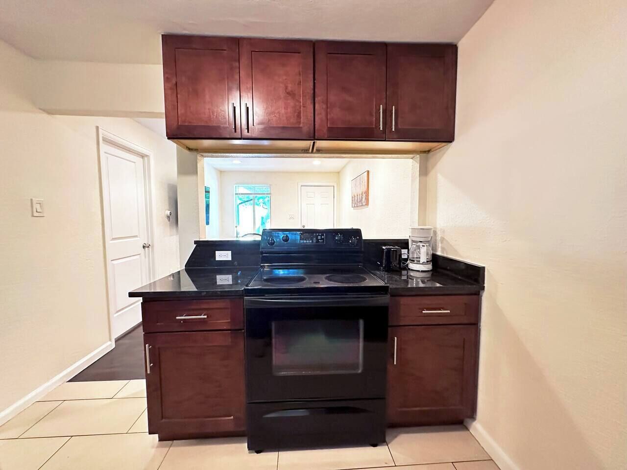 A kitchen with dark wooden cabinets, a black stove, and a countertop.