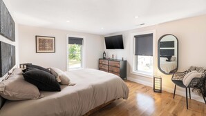A bedroom with a bed, dresser, TV, and a chair. - ALL NEW, walk to North Conway Village + Railroad, fire pit (Conway)