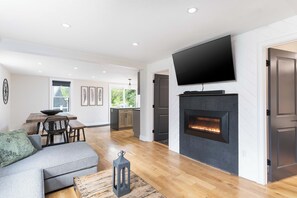 Smart TV, lareira, livros, aparelho de som