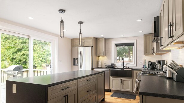 A modern kitchen with a large island, stainless steel appliances, and ample natural light from large windows. - ALL NEW, walk to North Conway Village + Railroad, fire pit (Conway)