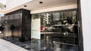 Un edificio moderno con ingresso in vetro, un cancello in metallo e un balcone con ringhiere.